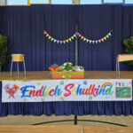 Eine Bühne mit einem Banner mit der Aufschrift "Endlich Schulkind"